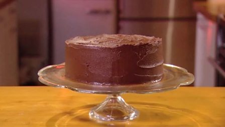 Icing a cake with chocolate ganache